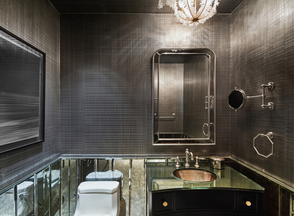 Esempio di un bagno di servizio chic con pareti grigie, consolle stile comò, ante nere, piastrelle grigie, piastrelle a specchio, lavabo sottopiano e top in vetro