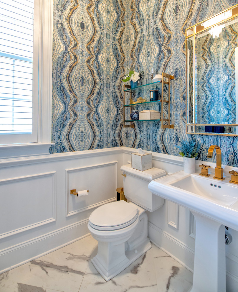 Inspiration for a large contemporary marble floor, white floor and wallpaper powder room remodel in New York with white cabinets, a two-piece toilet, multicolored walls, a pedestal sink and a freestanding vanity