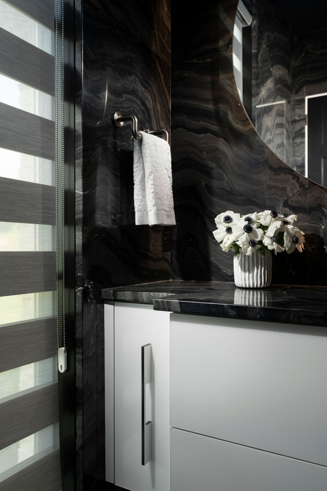 Inredning av ett modernt stort svart svart toalett, med släta luckor, vita skåp, en bidé, svart kakel, marmorkakel, svarta väggar, marmorgolv, ett undermonterad handfat, marmorbänkskiva och svart golv