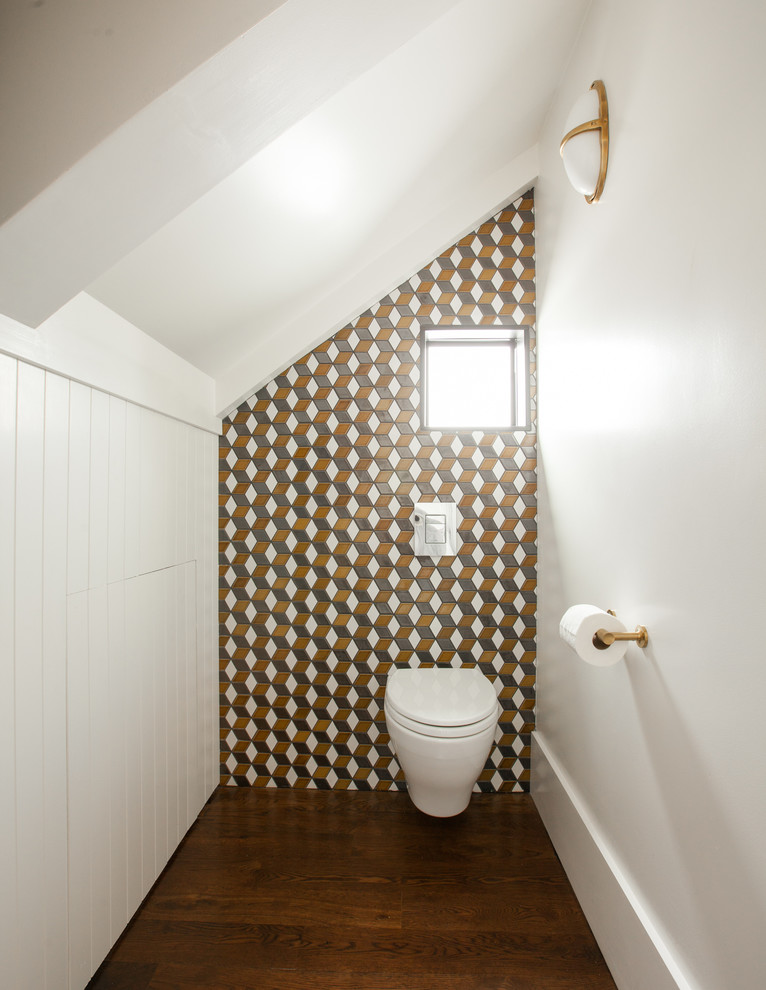 Aménagement d'un petit WC suspendu moderne avec des carreaux de céramique, un mur blanc, un sol en bois brun, une vasque et un carrelage multicolore.