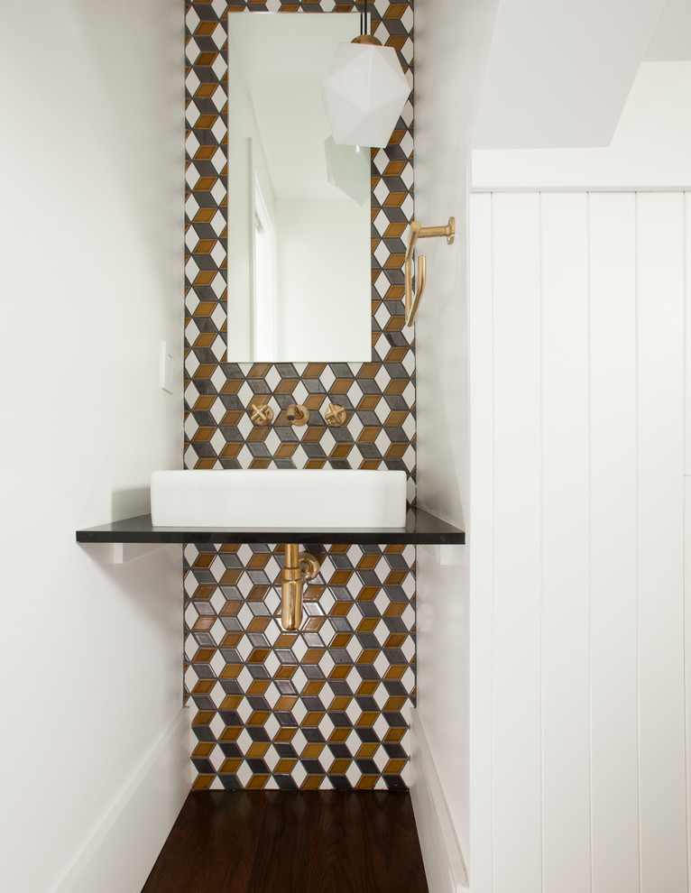 Idee per un piccolo bagno di servizio minimal con WC sospeso, lavabo a bacinella, pareti multicolore, parquet scuro e pavimento marrone