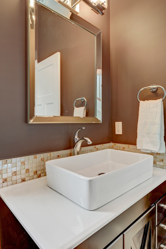 Design ideas for a small classic cloakroom in Calgary with recessed-panel cabinets, dark wood cabinets, a two-piece toilet, beige tiles, mosaic tiles, brown walls, porcelain flooring, a vessel sink and engineered stone worktops.