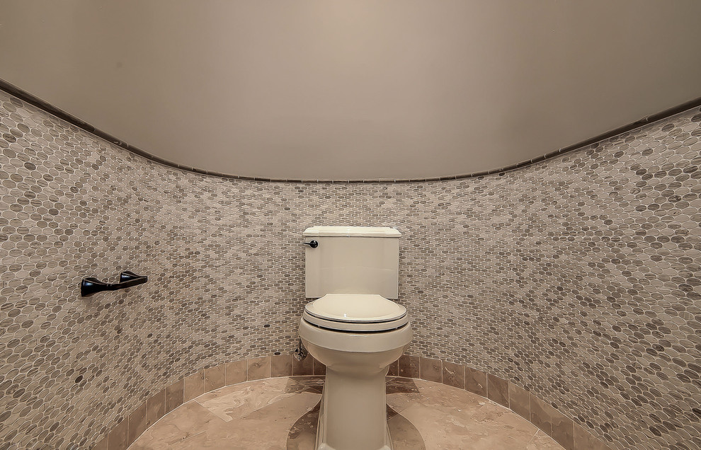 Photo of an expansive classic cloakroom in Phoenix with a submerged sink, medium wood cabinets, a two-piece toilet, multi-coloured tiles, stone tiles, grey walls and travertine flooring.