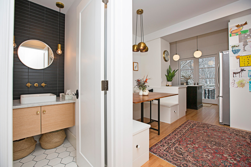 Inspiration for a small traditional cloakroom in Other with flat-panel cabinets, light wood cabinets, a one-piece toilet, black tiles, ceramic tiles, white walls, ceramic flooring, a vessel sink, marble worktops and white floors.