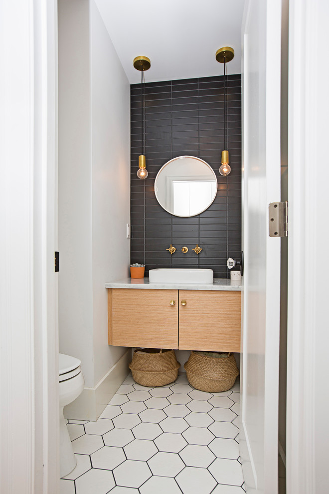 Стильный дизайн: маленький туалет в стиле неоклассика (современная классика) с плоскими фасадами, светлыми деревянными фасадами, унитазом-моноблоком, черной плиткой, керамической плиткой, белыми стенами, полом из керамической плитки, настольной раковиной, мраморной столешницей и белым полом для на участке и в саду - последний тренд