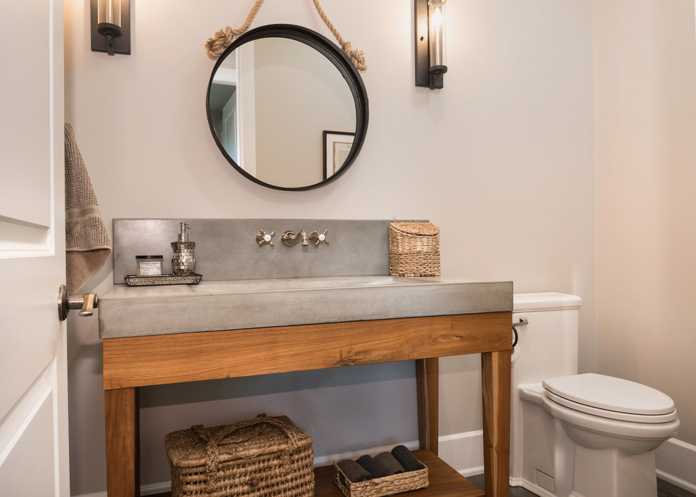 Photo of a large traditional cloakroom in Vancouver with open cabinets, medium wood cabinets, a two-piece toilet, beige walls, dark hardwood flooring, an integrated sink, concrete worktops and brown floors.
