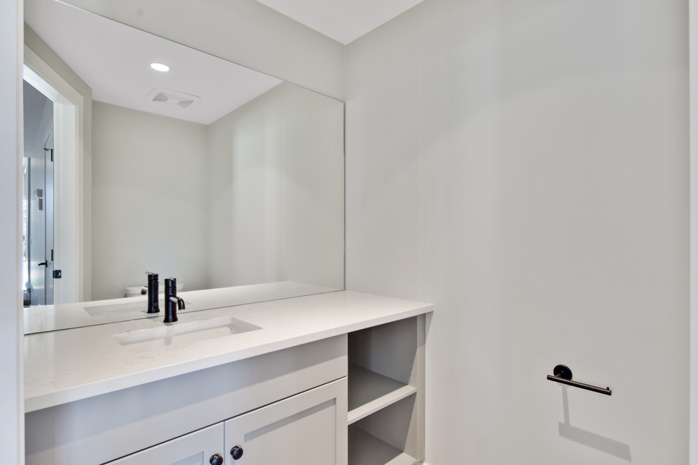 Foto di un piccolo bagno di servizio stile americano con ante in stile shaker, ante grigie, WC monopezzo, pareti bianche, lavabo sottopiano, top in quarzite e top bianco