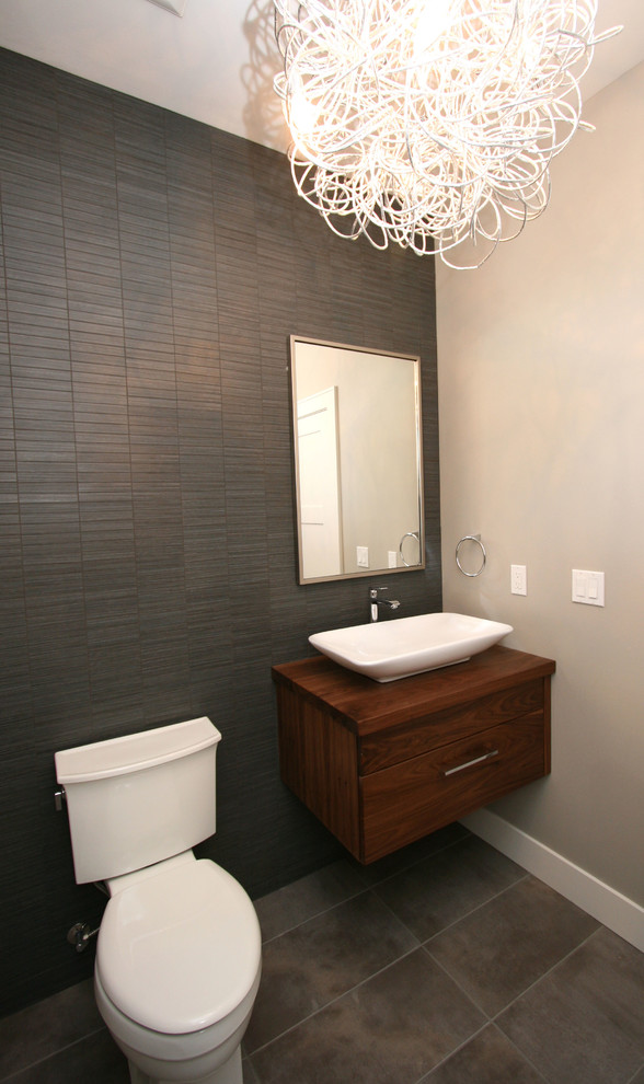Cette photo montre un petit WC et toilettes tendance en bois brun avec une vasque, un placard en trompe-l'oeil, un plan de toilette en bois, WC séparés, un carrelage noir, un mur gris, un sol en carrelage de porcelaine et un plan de toilette marron.
