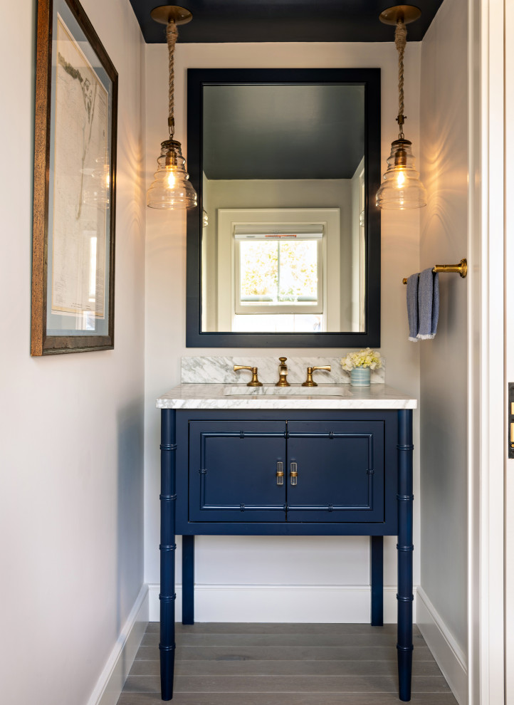Inspiration for a coastal medium tone wood floor and gray floor powder room remodel in Boston with gray cabinets, gray walls, an undermount sink, white countertops and a freestanding vanity