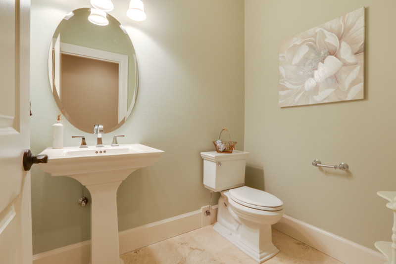 Стильный дизайн: туалет среднего размера в стиле неоклассика (современная классика) с унитазом-моноблоком, зелеными стенами, мраморным полом, раковиной с пьедесталом и бежевым полом - последний тренд
