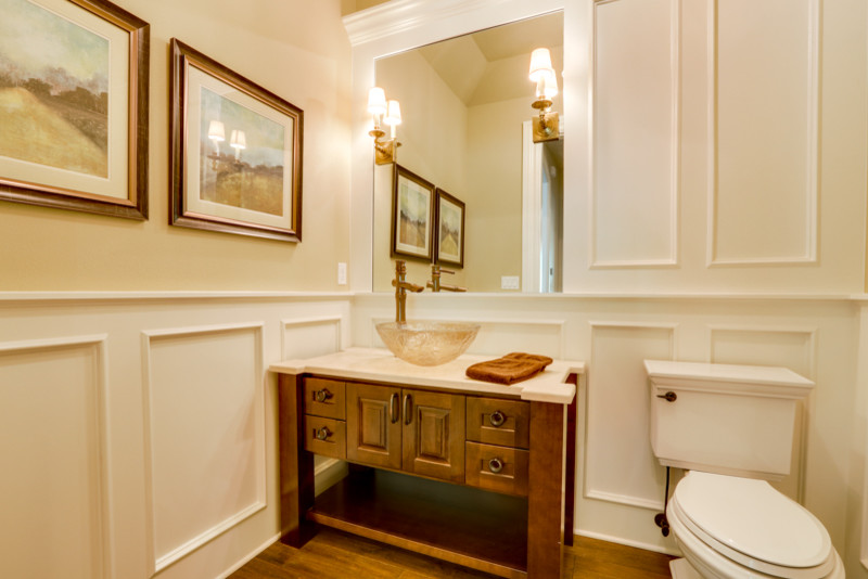 Mid-sized elegant dark wood floor and brown floor powder room photo in Portland with furniture-like cabinets, medium tone wood cabinets, white walls, a vessel sink, quartz countertops and a one-piece toilet