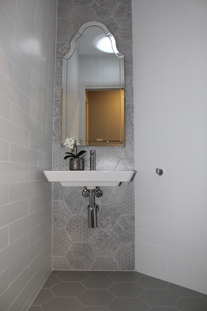 Exemple d'un petit WC et toilettes chic avec un carrelage multicolore, des carreaux de porcelaine, un mur multicolore, un sol en carrelage de porcelaine et un sol gris.