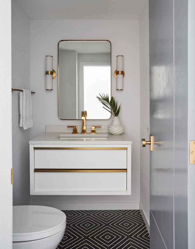 シカゴにあるコンテンポラリースタイルのおしゃれなトイレ・洗面所 (フラットパネル扉のキャビネット、白いキャビネット、白い壁、セメントタイルの床、アンダーカウンター洗面器、黒い床、白い洗面カウンター) の写真