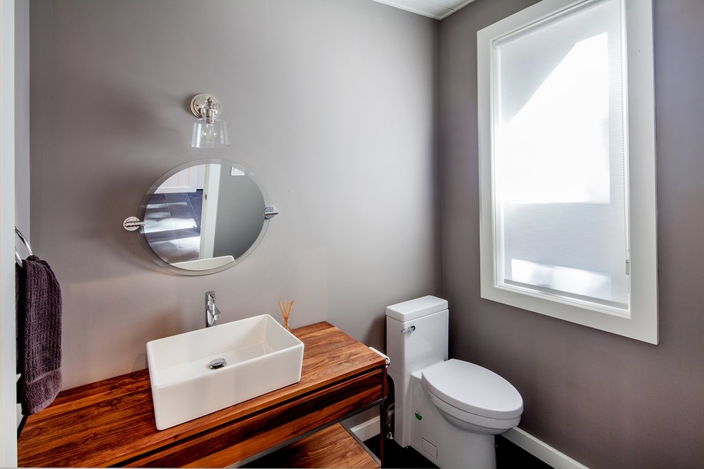 This is an example of a medium sized contemporary cloakroom in Toronto with open cabinets, grey walls, dark hardwood flooring, a pedestal sink, wooden worktops and brown floors.