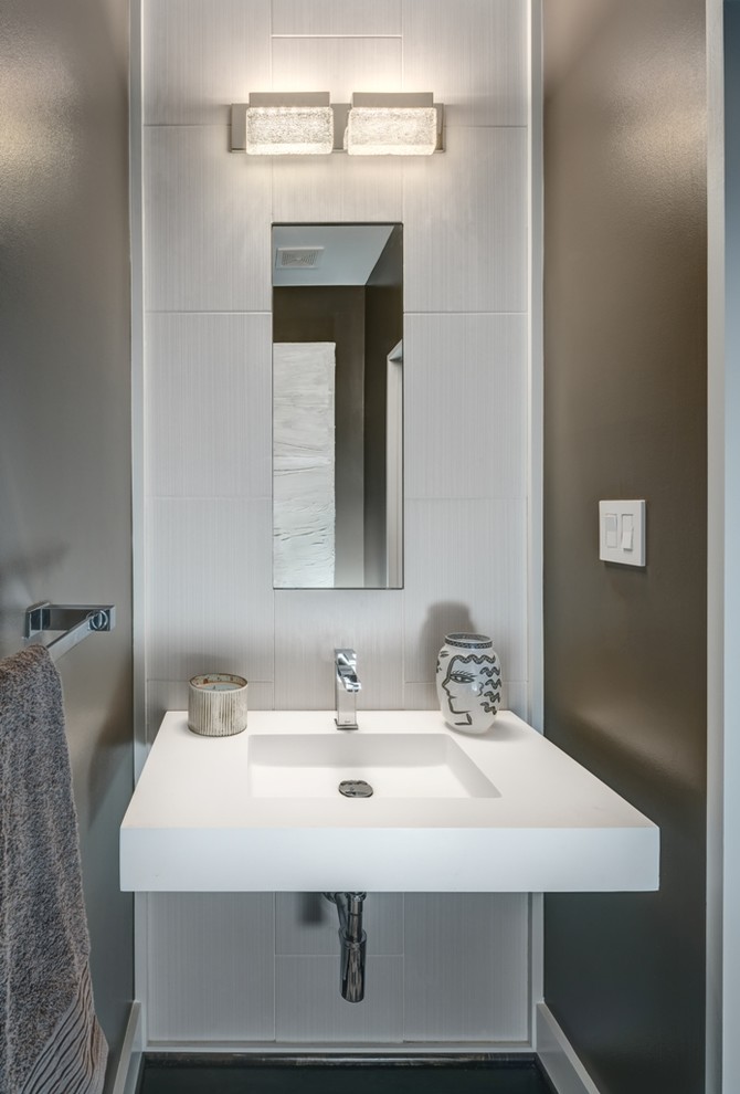 Inspiration pour un WC et toilettes design avec un carrelage gris, des carreaux de porcelaine, un mur marron, parquet foncé, un lavabo intégré et un plan de toilette en surface solide.