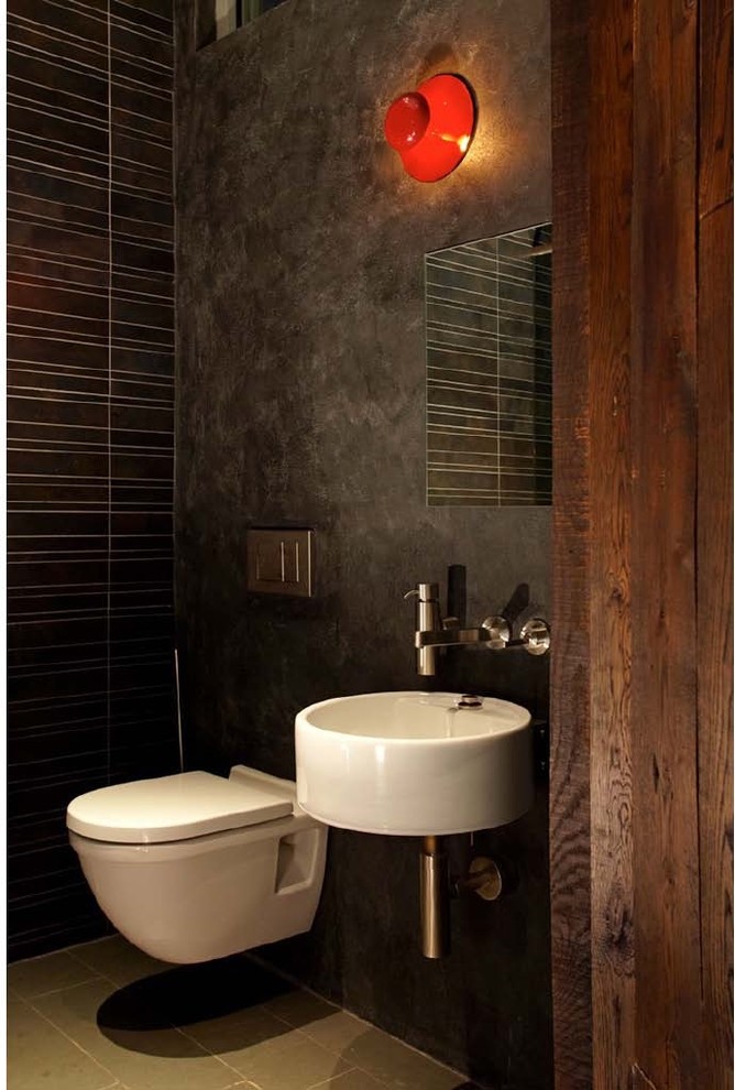 Inspiration för industriella toaletter, med ett väggmonterat handfat och en vägghängd toalettstol