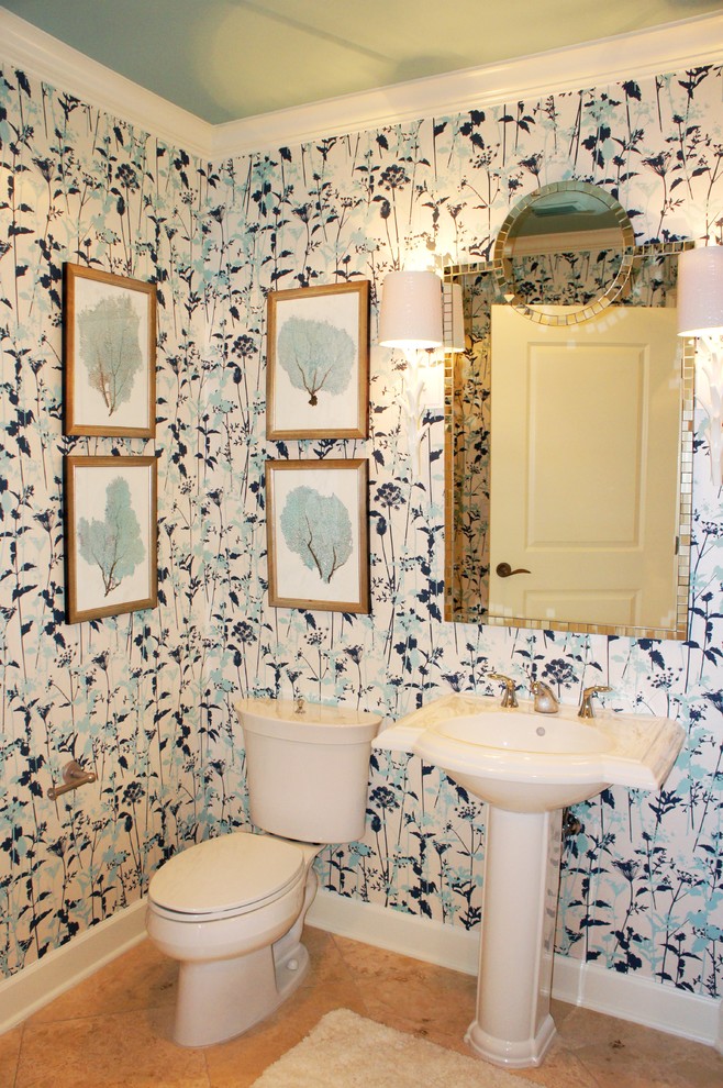 На фото: туалет среднего размера в современном стиле с раковиной с пьедесталом, раздельным унитазом, разноцветными стенами и полом из травертина с