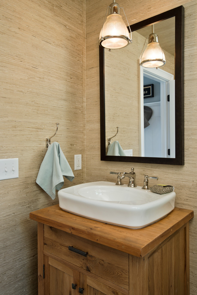 Idee per un piccolo bagno di servizio tradizionale con lavabo a bacinella, consolle stile comò, ante in legno scuro, top in legno, pareti beige e top marrone