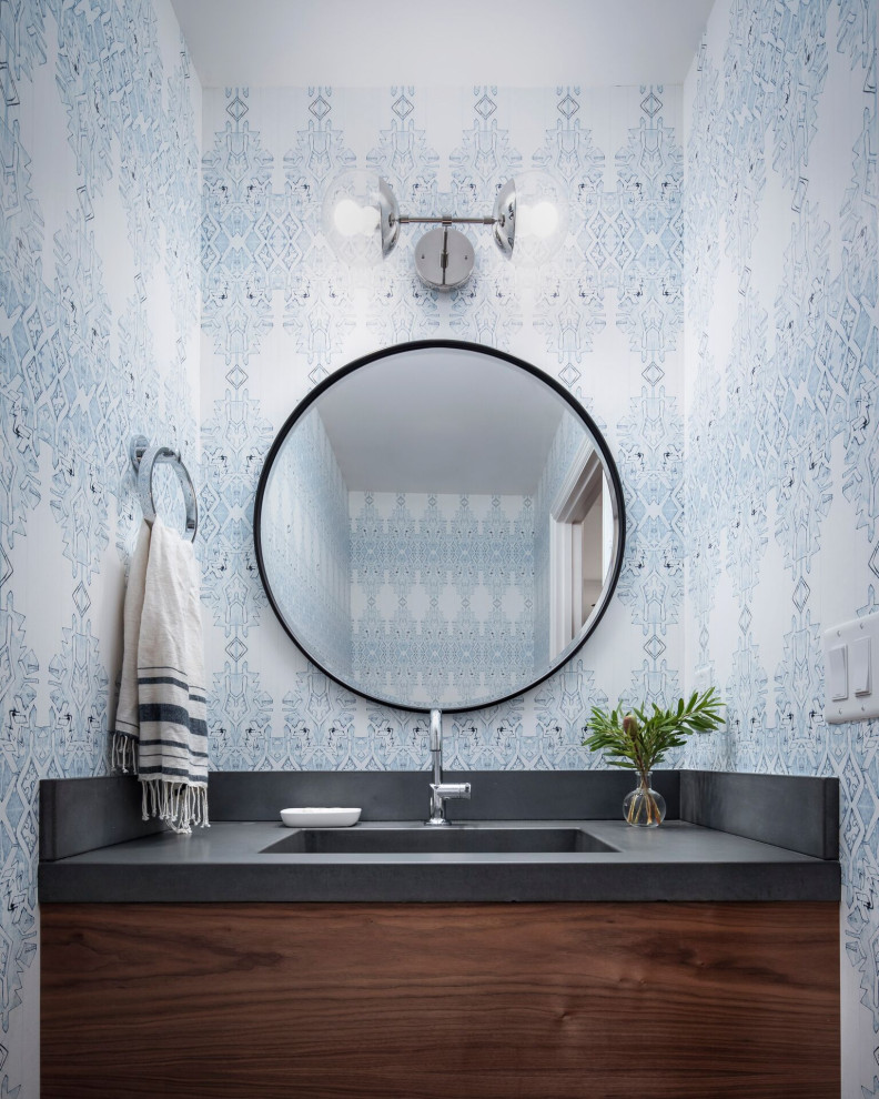 Inspiration for a small classic cloakroom in Other with flat-panel cabinets, brown cabinets, a two-piece toilet, blue walls, medium hardwood flooring, an integrated sink, concrete worktops, brown floors and grey worktops.