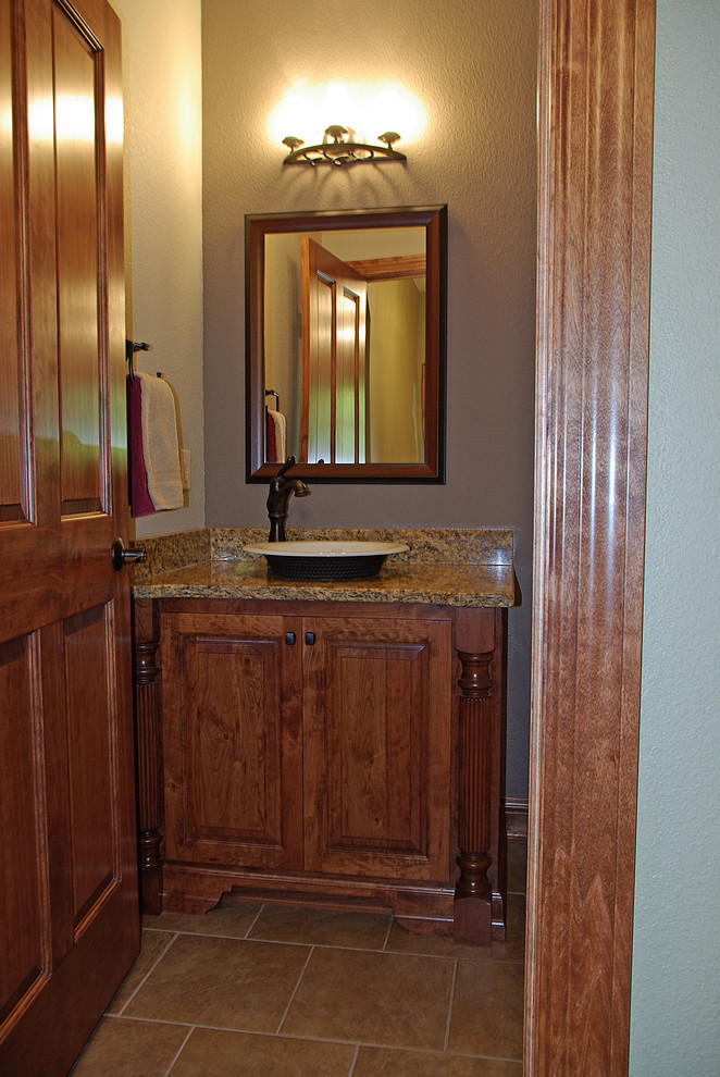 Ejemplo de aseo clásico de tamaño medio con lavabo sobreencimera, armarios tipo mueble, puertas de armario de madera oscura, paredes púrpuras y suelo de travertino