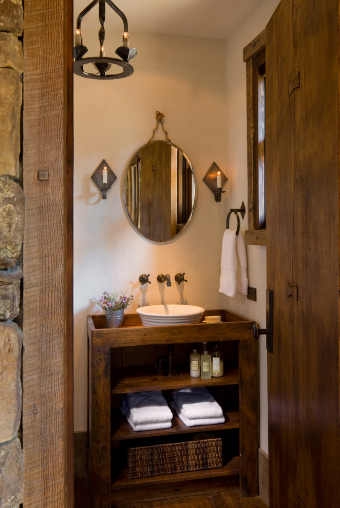 Urige Gästetoilette mit Aufsatzwaschbecken, beiger Wandfarbe, offenen Schränken und dunklen Holzschränken in Sonstige