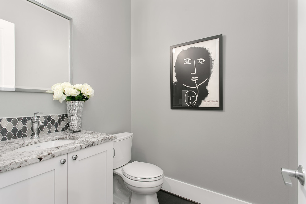 Powder room - small craftsman gray tile and porcelain tile porcelain tile powder room idea in Seattle with shaker cabinets, a two-piece toilet, an undermount sink, white cabinets, gray walls and granite countertops