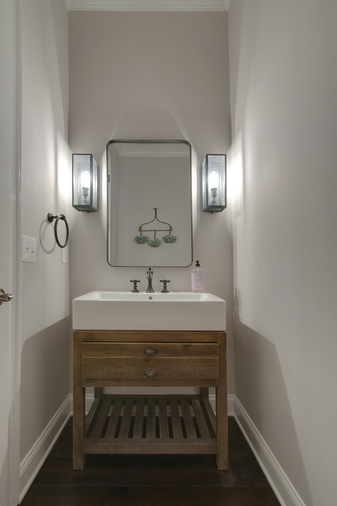 Exemple d'un petit WC et toilettes chic avec un placard en trompe-l'oeil, des portes de placard marrons, WC à poser, un carrelage gris, un mur gris, parquet foncé, une vasque, un sol marron et un plan de toilette blanc.