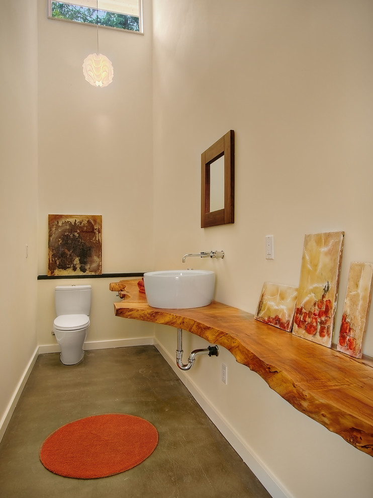 Moderne Gästetoilette mit Aufsatzwaschbecken, Betonboden, Waschtisch aus Holz und brauner Waschtischplatte in Seattle