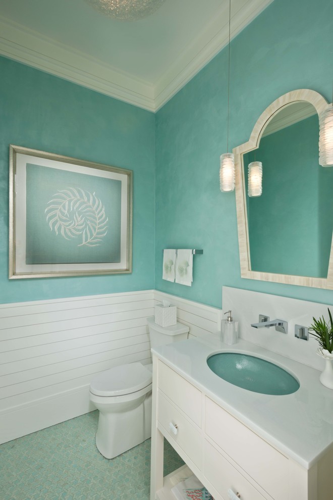 Imagen de aseo costero con armarios con paneles lisos, puertas de armario blancas, paredes verdes, lavabo bajoencimera, suelo verde y encimeras blancas