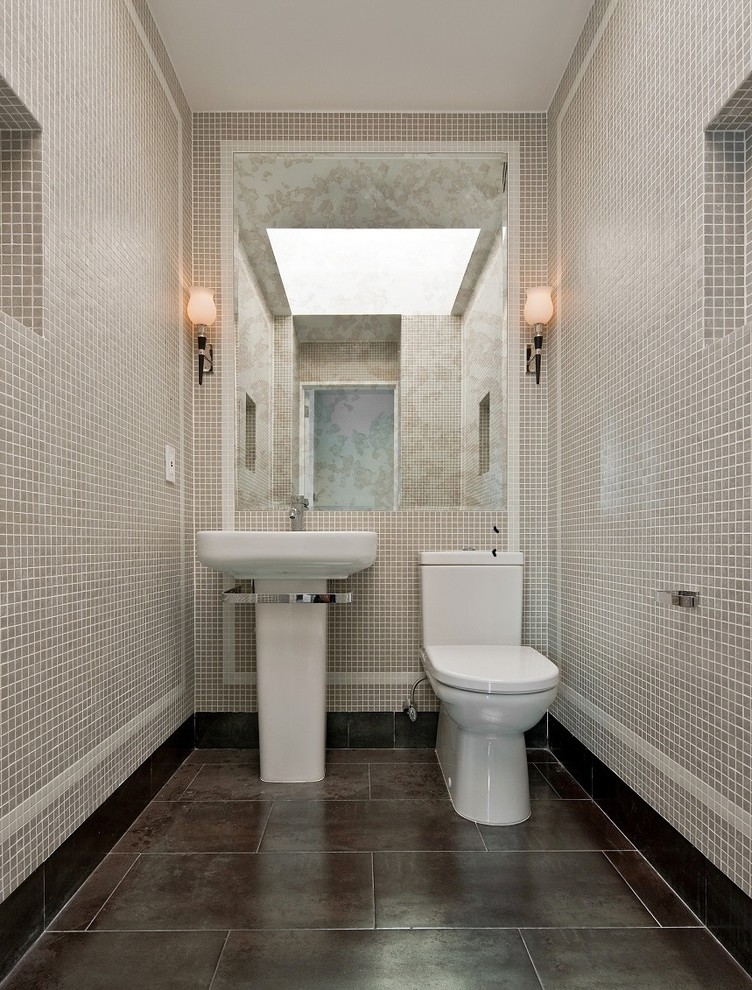 ニューヨークにあるコンテンポラリースタイルのおしゃれなトイレ・洗面所 (ペデスタルシンク、グレーのタイル、モザイクタイル) の写真