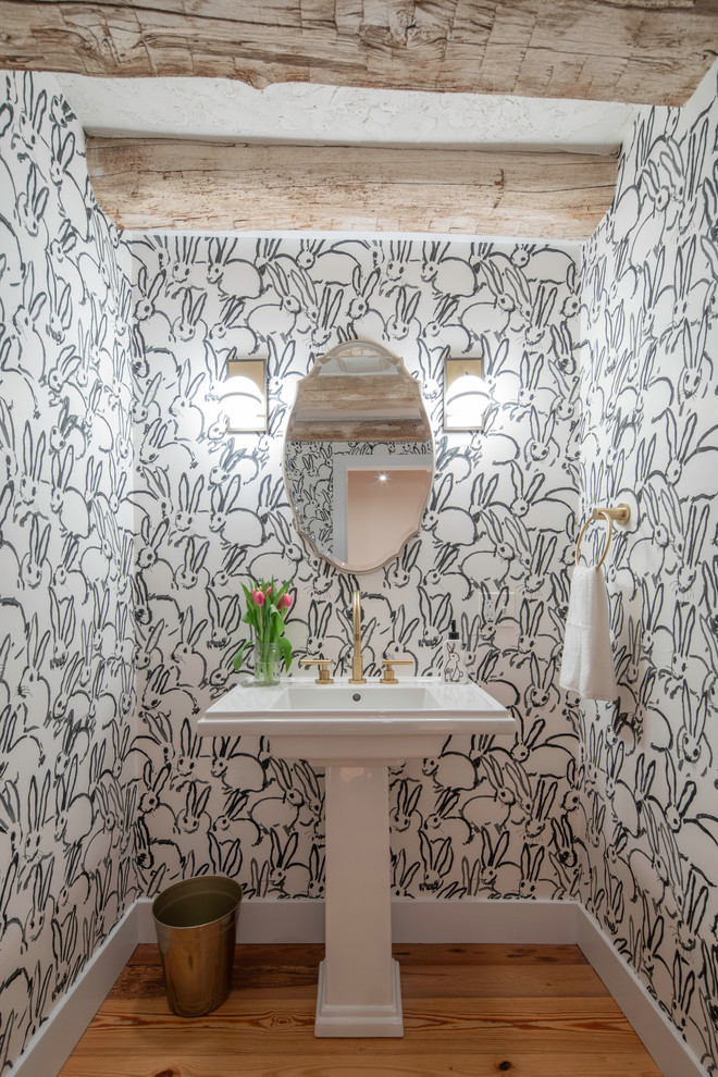 Idée de décoration pour un WC et toilettes champêtre avec un lavabo de ferme, un mur multicolore, un sol en bois brun et un sol marron.