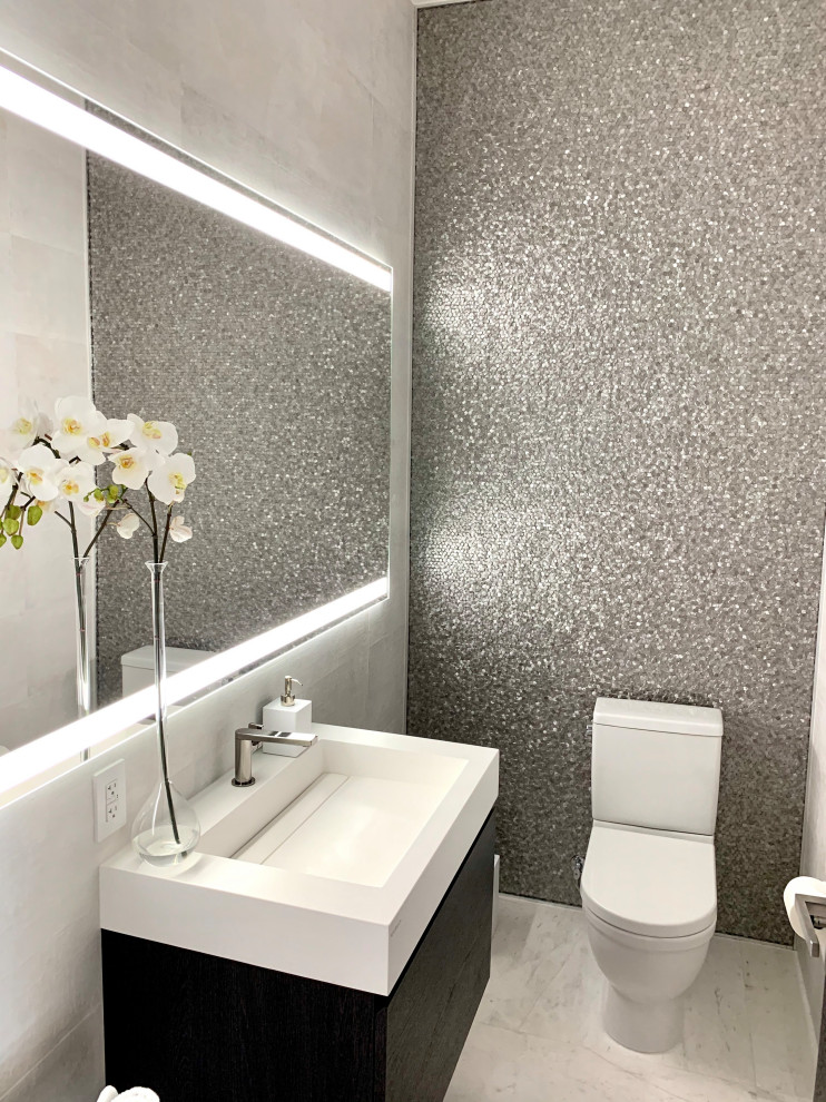 Photo of a medium sized contemporary cloakroom in Miami with flat-panel cabinets, dark wood cabinets, a two-piece toilet, grey tiles, metal tiles, grey walls, marble flooring, an integrated sink, engineered stone worktops, white floors, white worktops and a floating vanity unit.