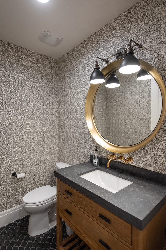Foto på ett lantligt grå toalett, med möbel-liknande, skåp i mellenmörkt trä, grå väggar, ett undermonterad handfat och svart golv