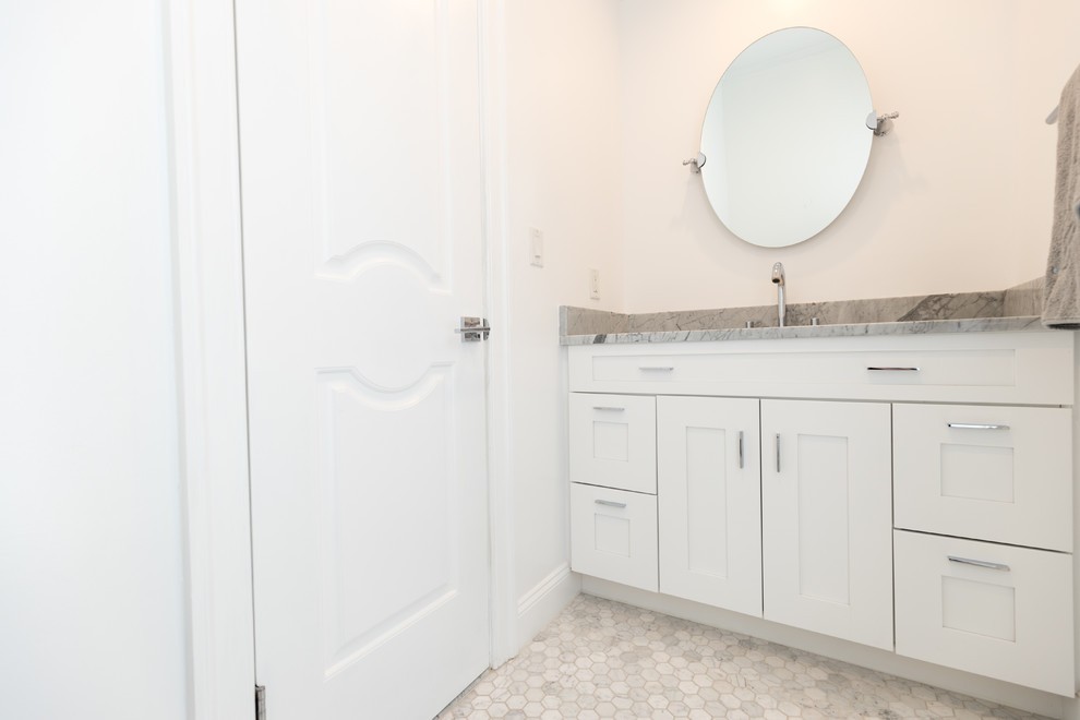 ワシントンD.C.にある中くらいなコンテンポラリースタイルのおしゃれなトイレ・洗面所 (白いキャビネット、分離型トイレ、白いタイル、サブウェイタイル、白い壁、セラミックタイルの床、アンダーカウンター洗面器、人工大理石カウンター、白い床) の写真