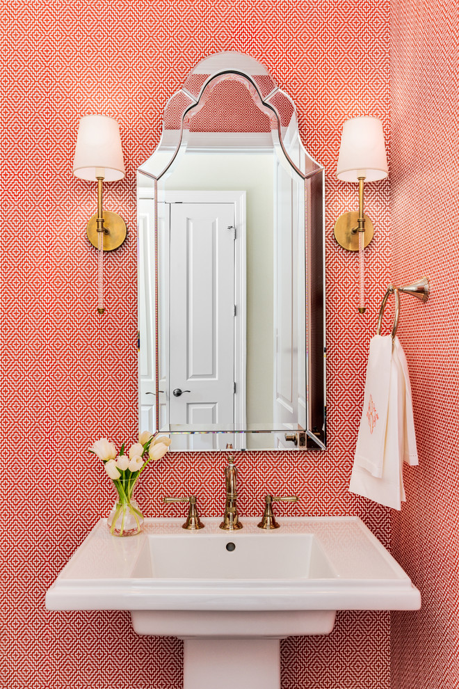 マイアミにあるトラディショナルスタイルのおしゃれなトイレ・洗面所 (ペデスタルシンク、赤い壁) の写真