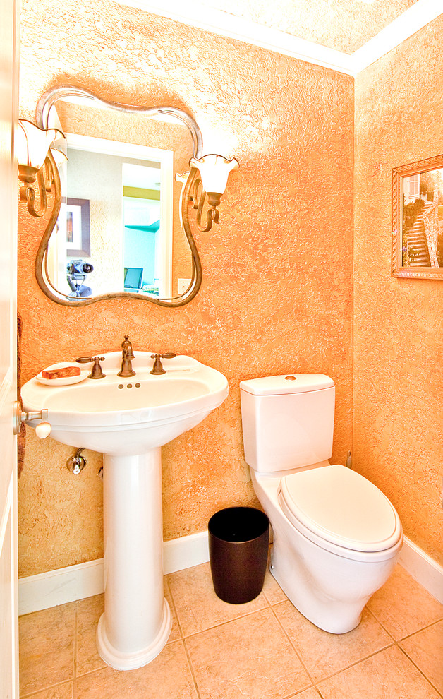 Esempio di un piccolo bagno di servizio classico con WC a due pezzi, pareti beige, pavimento con piastrelle in ceramica, lavabo a colonna e pavimento beige