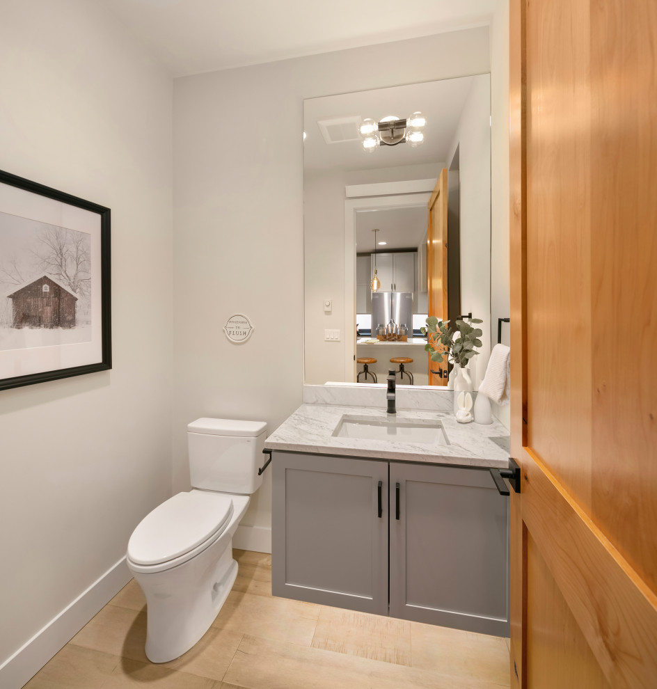Foto di un bagno di servizio design con ante grigie, pareti bianche, parquet chiaro, lavabo sottopiano, top in marmo e top bianco