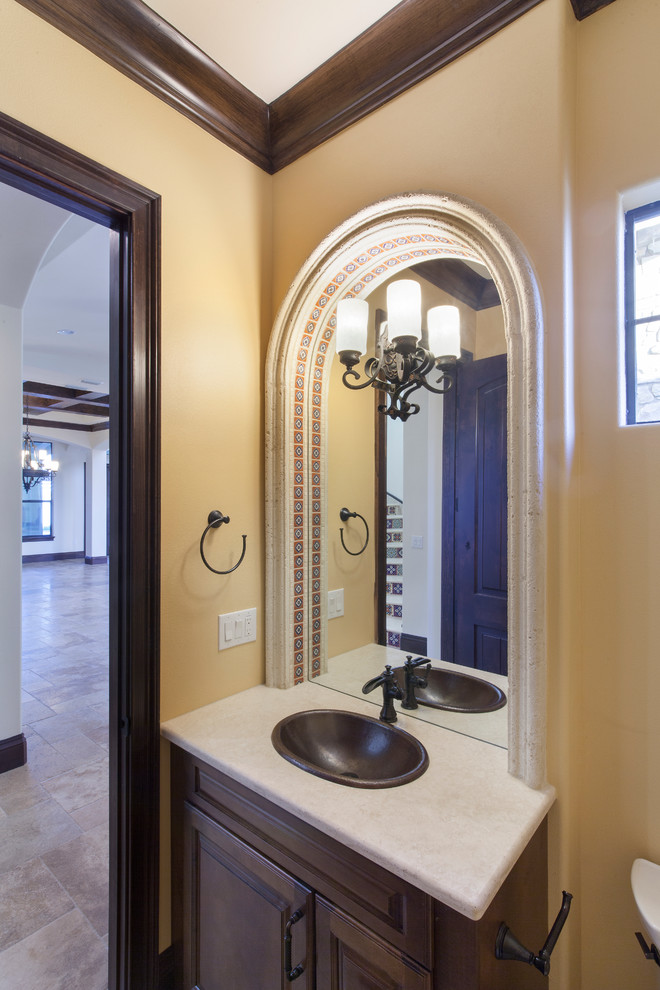 Kleine Mediterrane Gästetoilette mit profilierten Schrankfronten, dunklen Holzschränken, Toilette mit Aufsatzspülkasten, Keramikfliesen, beiger Wandfarbe, Einbauwaschbecken und Granit-Waschbecken/Waschtisch in Orlando