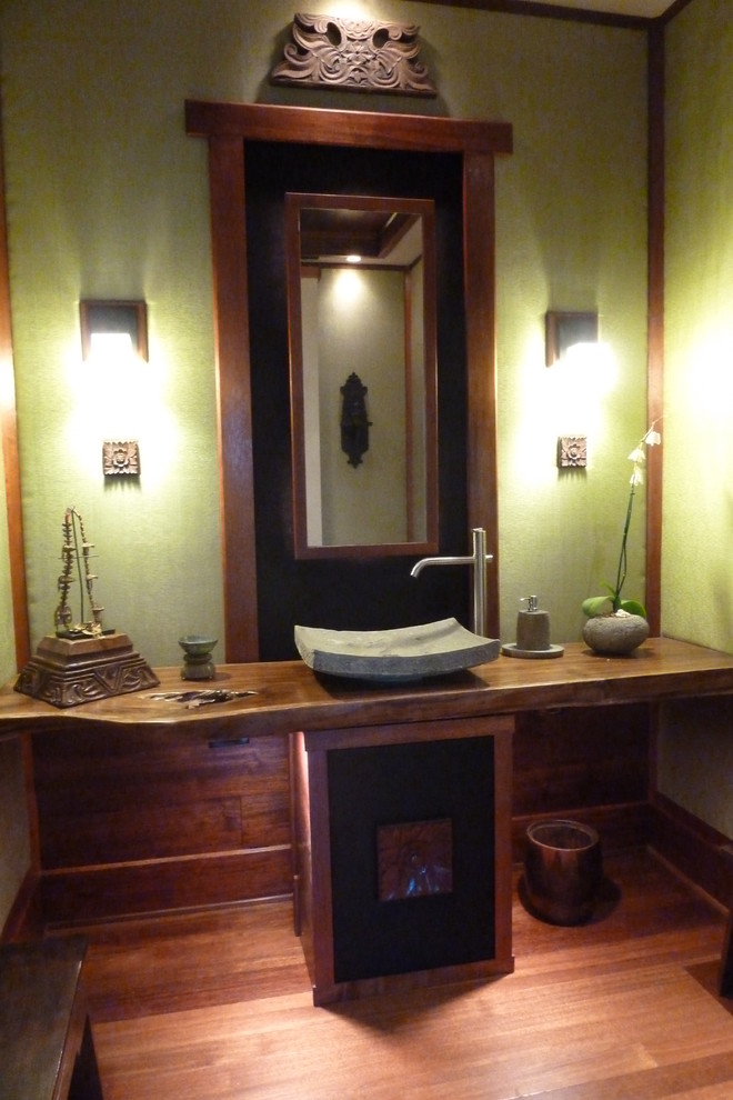 Inspiration pour un WC et toilettes ethnique en bois brun de taille moyenne avec un mur vert, un sol en bois brun, une vasque et un plan de toilette en bois.