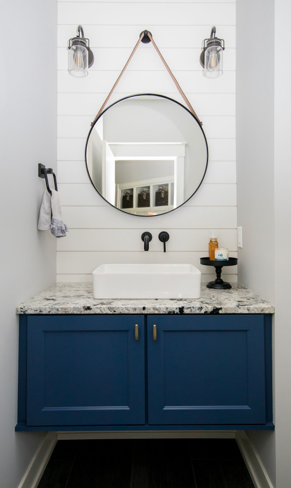 Inspiration for a classic cloakroom in Grand Rapids with recessed-panel cabinets, blue cabinets, a two-piece toilet, grey walls, ceramic flooring, a vessel sink, granite worktops, grey floors, multi-coloured worktops, a floating vanity unit and tongue and groove walls.