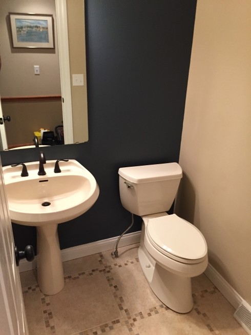 クリーブランドにあるお手頃価格の小さなトランジショナルスタイルのおしゃれなトイレ・洗面所 (ペデスタルシンク、分離型トイレ、ベージュのタイル、青い壁、磁器タイルの床) の写真