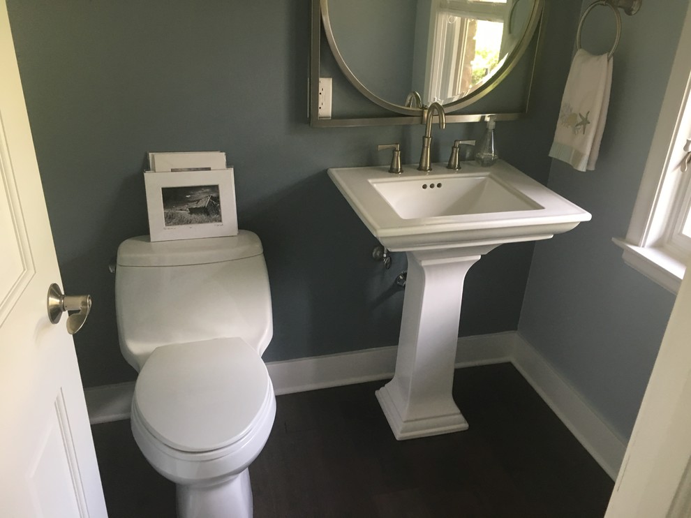 Inspiration for a small beach style cloakroom in Milwaukee with a one-piece toilet, blue walls, dark hardwood flooring, a pedestal sink and brown floors.