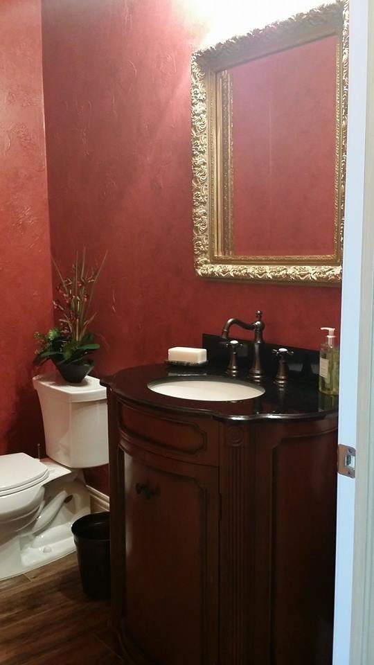 Inspiration for a small mediterranean medium tone wood floor and brown floor powder room remodel in Miami with beaded inset cabinets, dark wood cabinets, a two-piece toilet, red walls and an undermount sink