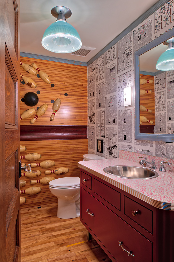 Eklektische Gästetoilette mit flächenbündigen Schrankfronten, roten Schränken, Wandtoilette mit Spülkasten, braunem Holzboden, Einbauwaschbecken, braunem Boden und roter Waschtischplatte in Minneapolis