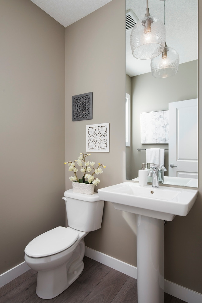 Ispirazione per un piccolo bagno di servizio contemporaneo con WC monopezzo, pareti beige, parquet chiaro e lavabo a colonna