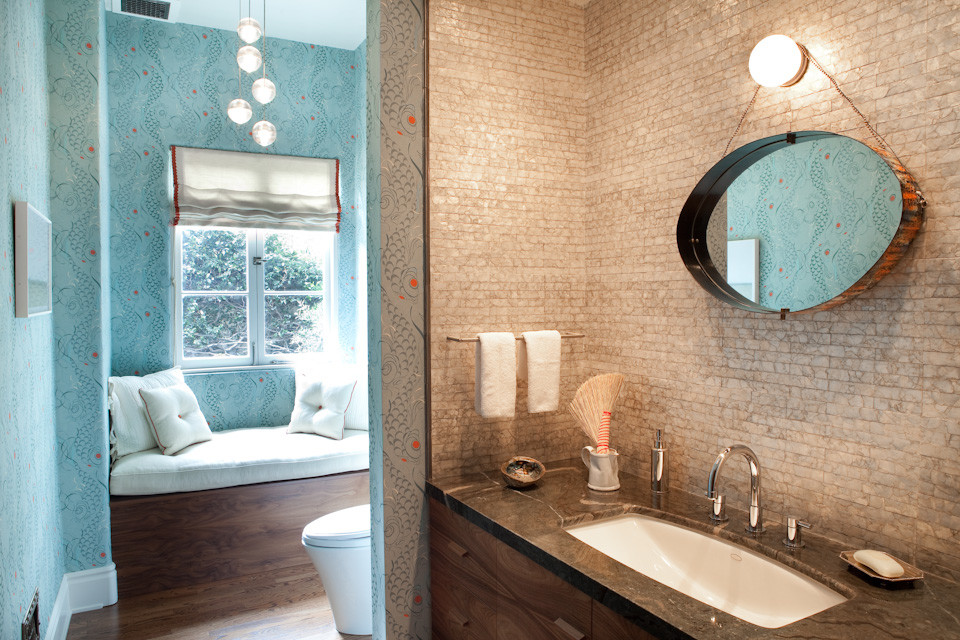 Esempio di un bagno di servizio minimalista di medie dimensioni con lavabo sottopiano, ante lisce, ante in legno scuro, top in marmo, WC monopezzo e pavimento in legno massello medio