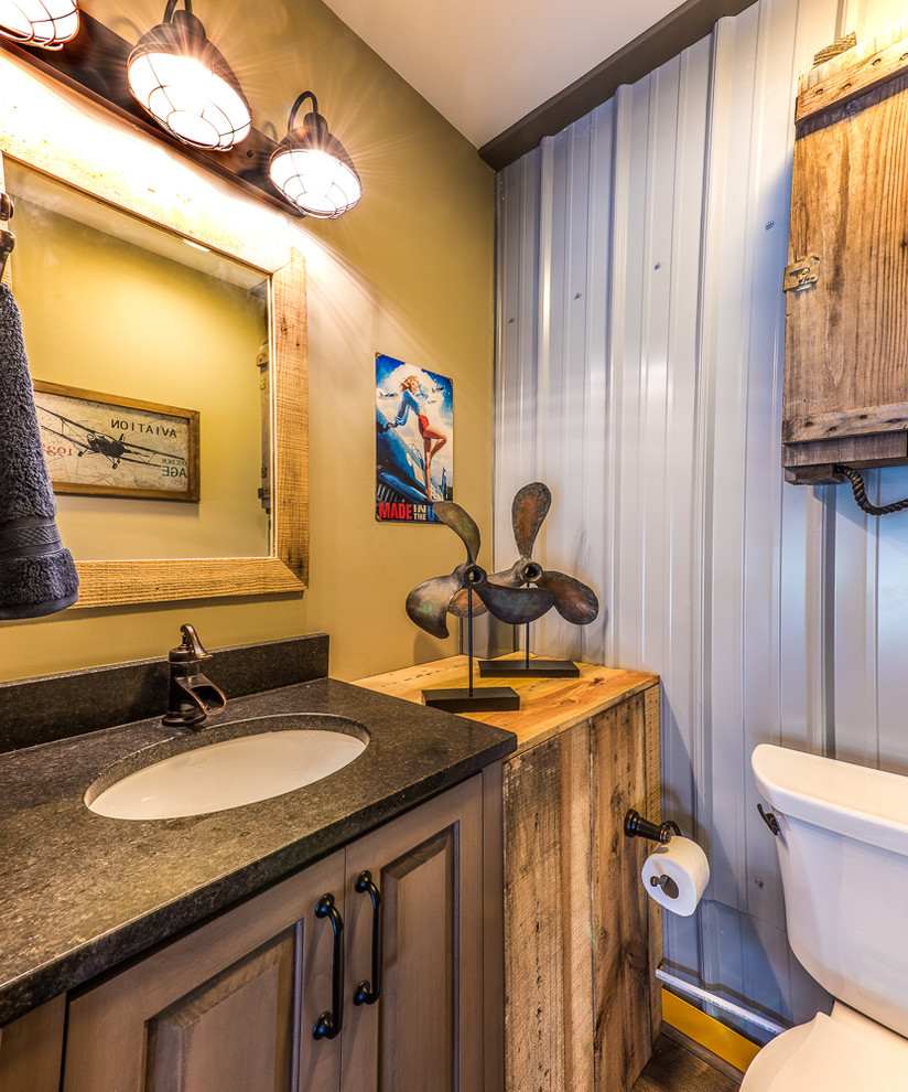 На фото: туалет в стиле лофт с фасадами с выступающей филенкой, раздельным унитазом и врезной раковиной