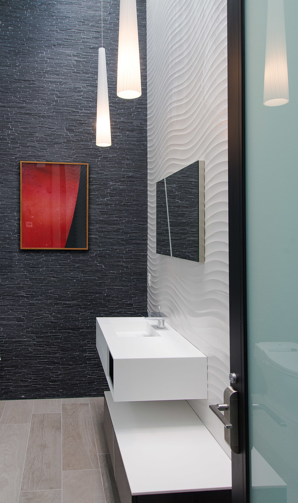 На фото: туалет в современном стиле с подвесной раковиной, белой плиткой и черной плиткой с