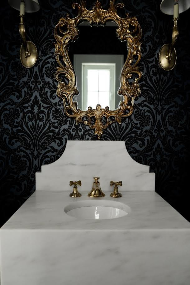 Cette image montre un WC et toilettes traditionnel de taille moyenne avec un lavabo suspendu, un mur noir et un plan de toilette en marbre.