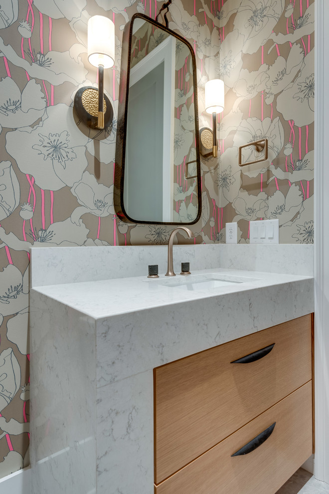 Immagine di un bagno di servizio minimal con ante lisce, ante in legno chiaro, lavabo sottopiano e top bianco